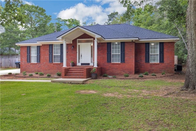 view of front of property featuring central air condition unit, brick siding, and roof with shingles