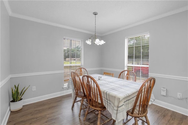 dining area with plenty of natural light, wood finished floors, a textured ceiling, a chandelier, and ornamental molding