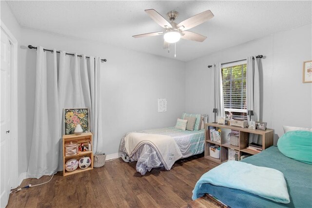 bedroom featuring wood finished floors, ceiling fan, and baseboards