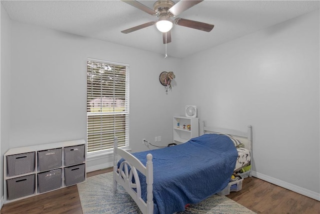 bedroom with wood finished floors, baseboards, and ceiling fan