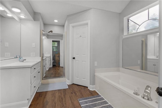 bathroom featuring wood finished floors, vanity, a garden tub, ensuite bath, and recessed lighting
