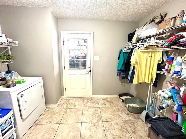 washroom featuring light tile patterned flooring, washing machine and dryer, and a textured ceiling