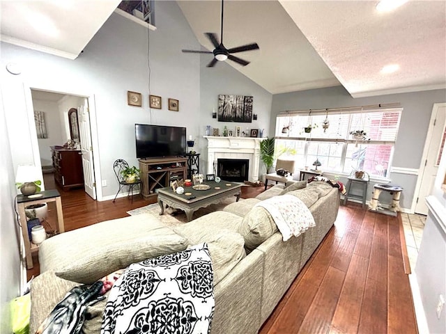 living room with crown molding, high vaulted ceiling, dark hardwood / wood-style floors, and ceiling fan