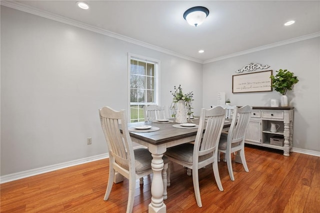 dining area with crown molding, wood finished floors, and baseboards