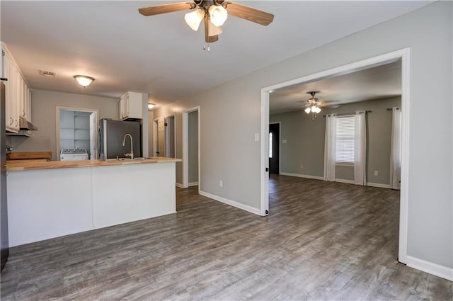 kitchen featuring wooden counters, dark hardwood / wood-style flooring, kitchen peninsula, ceiling fan, and white cabinets