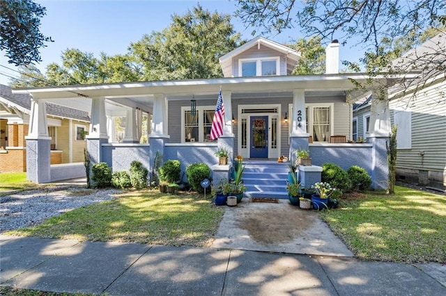 bungalow-style home with covered porch and a front lawn