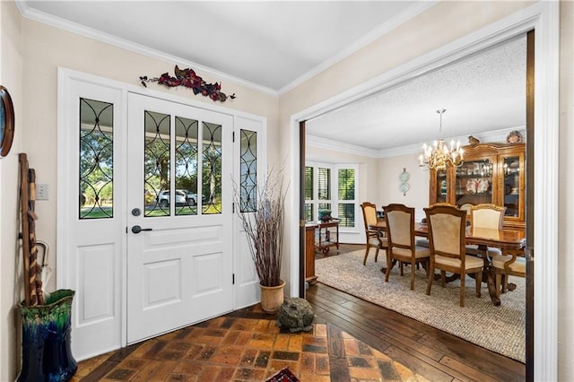 foyer with a notable chandelier, dark wood-type flooring, and crown molding