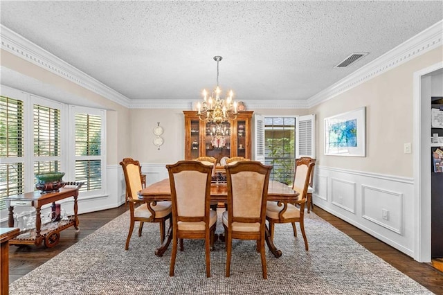 dining room with dark wood-type flooring, plenty of natural light, and ornamental molding