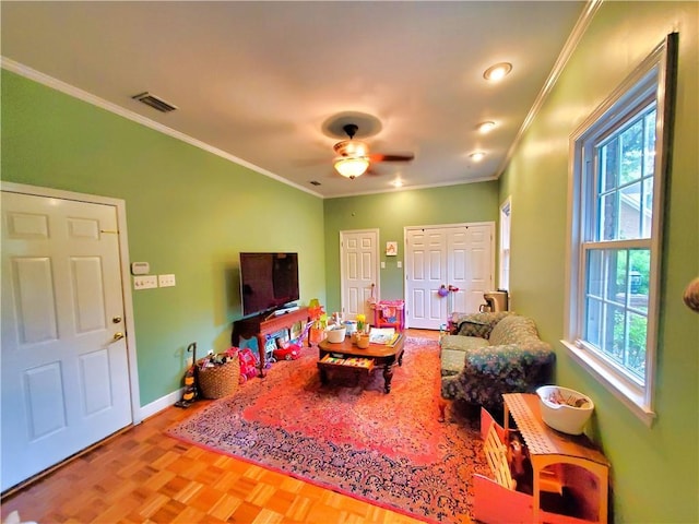 rec room with ceiling fan, visible vents, baseboards, and ornamental molding