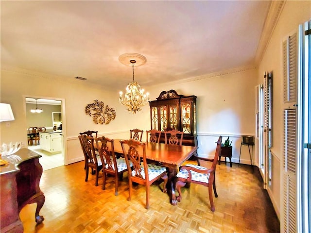 dining room featuring visible vents, baseboards, an inviting chandelier, and ornamental molding