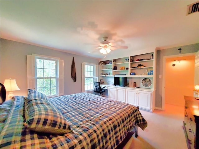 bedroom featuring visible vents, light colored carpet, and a ceiling fan