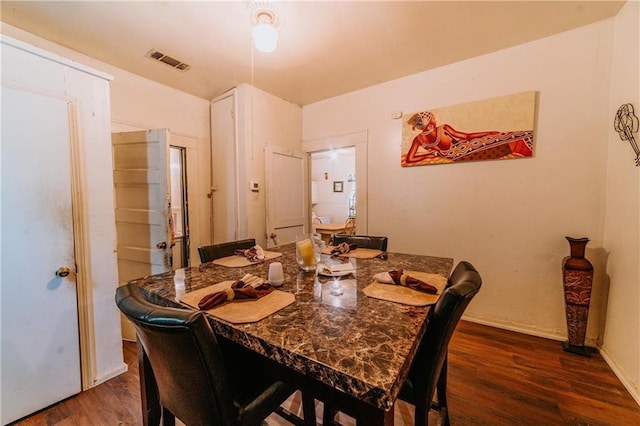 dining area featuring visible vents, baseboards, and wood finished floors