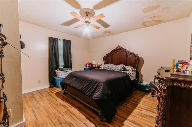 bedroom featuring baseboards, light wood-type flooring, and a ceiling fan