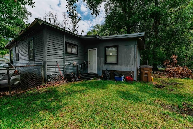 view of front of property featuring entry steps, a front yard, and fence