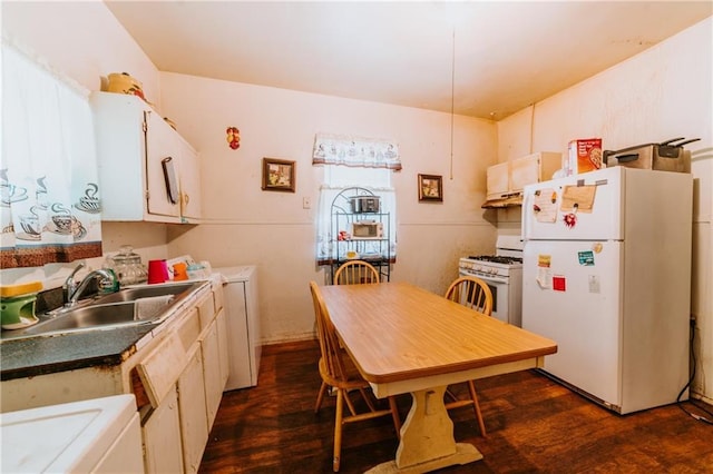 kitchen with white appliances, white cabinets, dark wood-type flooring, and a sink