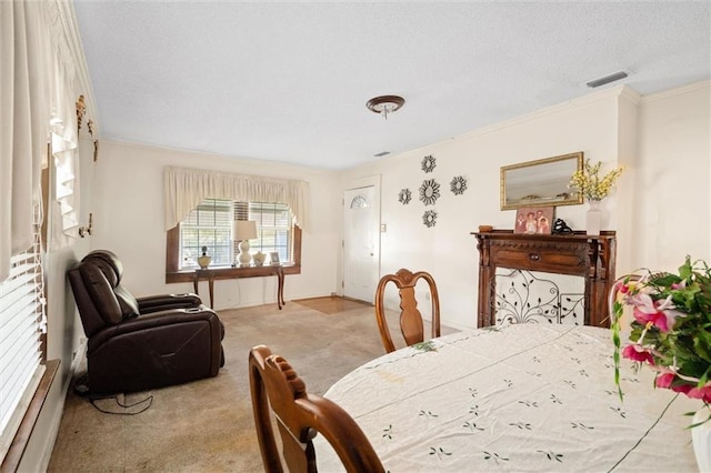 carpeted dining area with a textured ceiling and crown molding