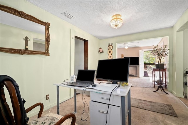 carpeted office with ceiling fan and a textured ceiling