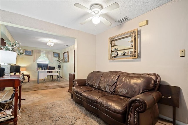 living room featuring carpet, a textured ceiling, and ceiling fan