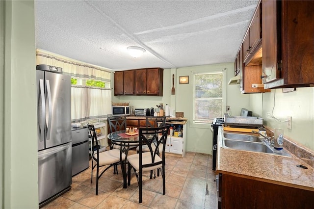 kitchen featuring a textured ceiling, stainless steel appliances, and sink