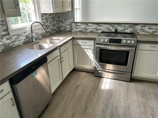 2365 Dog River Dr N, Mobile, AL 36605 - kitchen featuring stainless steel appliances, decorative backsplash, wood finished floors, and white cabinets