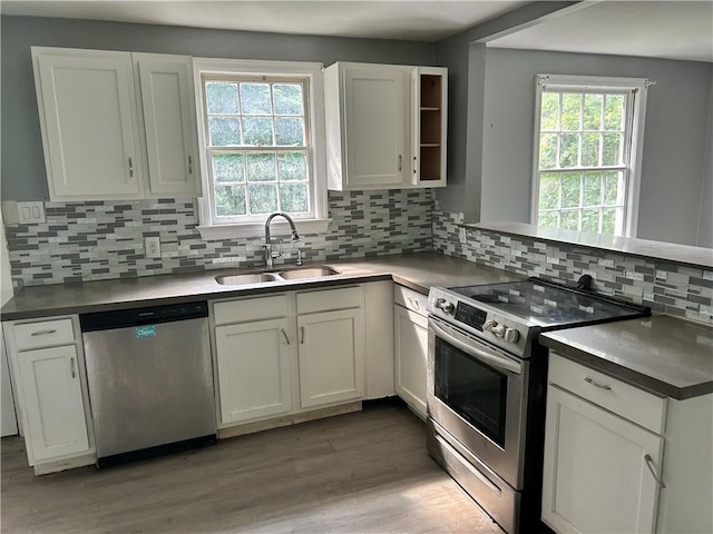 2365 Dog River Dr N, Mobile, AL 36605 - kitchen featuring stainless steel appliances, light wood-style flooring, white cabinetry, decorative backsplash, and a peninsula