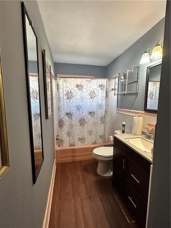 full bathroom featuring shower / tub combo, backsplash, vanity, hardwood / wood-style floors, and toilet