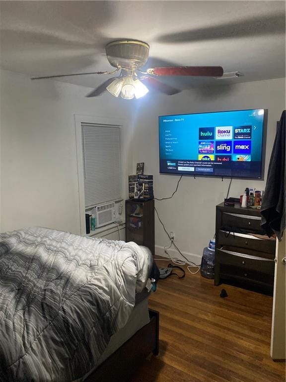 bedroom featuring ceiling fan, cooling unit, and dark hardwood / wood-style flooring