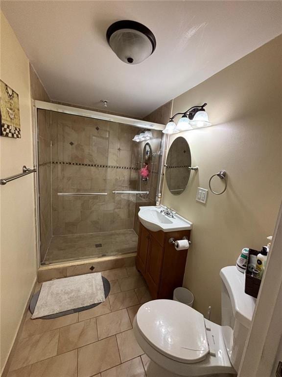 bathroom with tile patterned flooring, vanity, toilet, and a shower with door