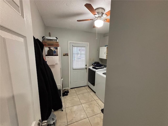 washroom featuring cabinets, ceiling fan, washing machine and dryer, light tile patterned floors, and a textured ceiling