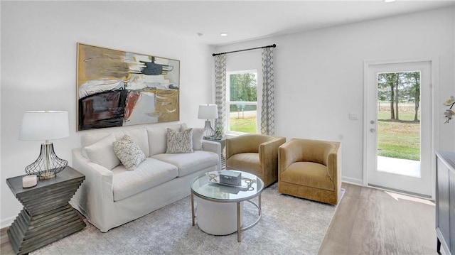 living room with plenty of natural light, light wood finished floors, recessed lighting, and baseboards