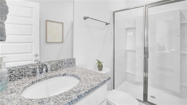 full bath with a stall shower, toilet, and vanity