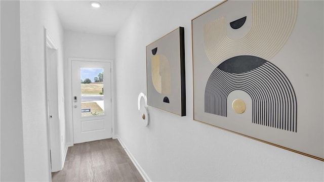 hall featuring wood finished floors, baseboards, and recessed lighting