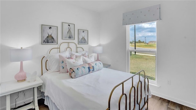 bedroom with wood finished floors and baseboards