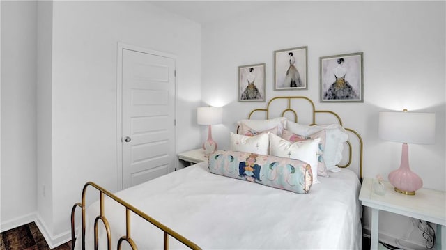 bedroom with baseboards and wood finished floors