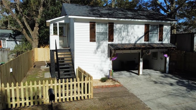 view of front of house featuring a garage, a fenced front yard, and driveway