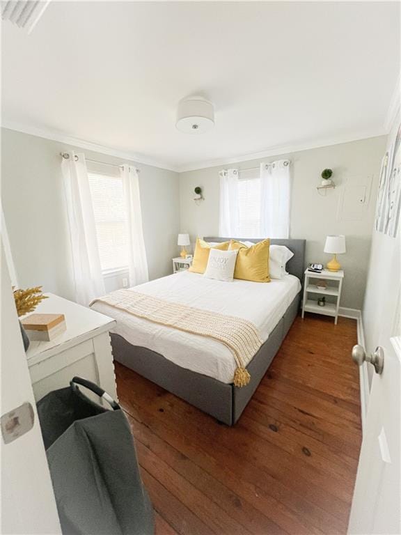 bedroom featuring multiple windows, crown molding, and hardwood / wood-style floors