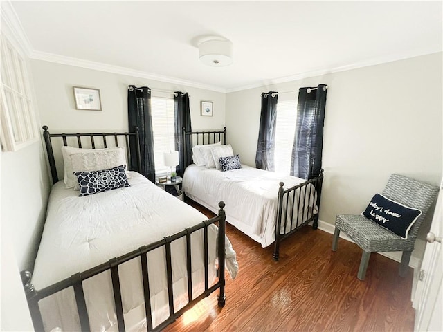 bedroom with ornamental molding, baseboards, and wood finished floors