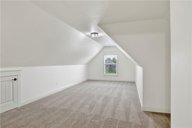 bonus room featuring lofted ceiling and light colored carpet