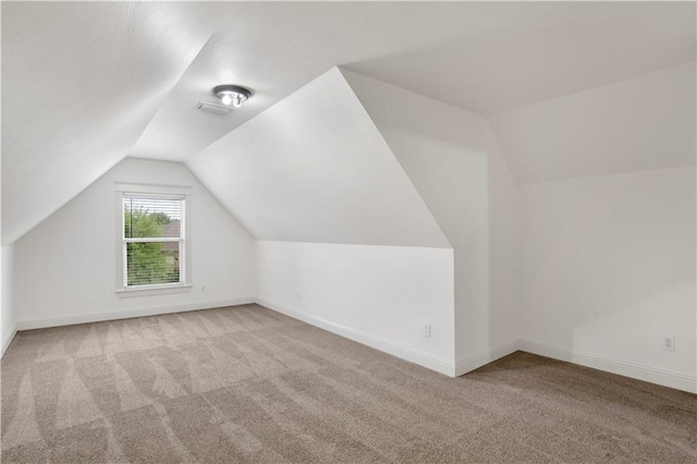 additional living space with vaulted ceiling and light colored carpet