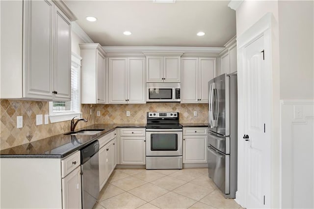 kitchen featuring white cabinetry, appliances with stainless steel finishes, sink, and dark stone countertops