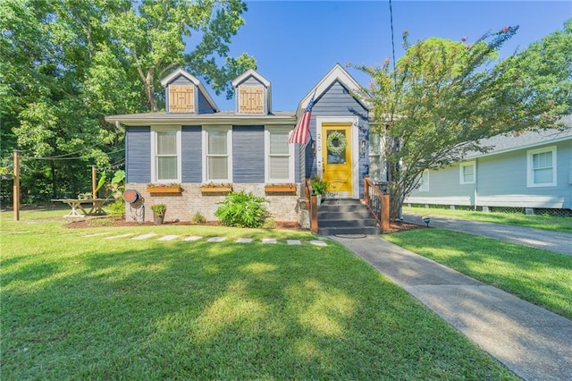 view of front facade featuring brick siding and a front yard