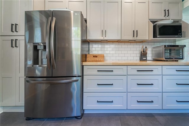 kitchen featuring white cabinetry, stainless steel appliances, and tasteful backsplash