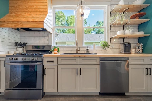 kitchen featuring sink, decorative backsplash, range with gas stovetop, and stainless steel dishwasher