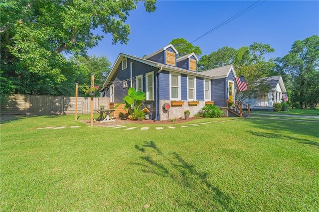 view of home's exterior with fence and a yard