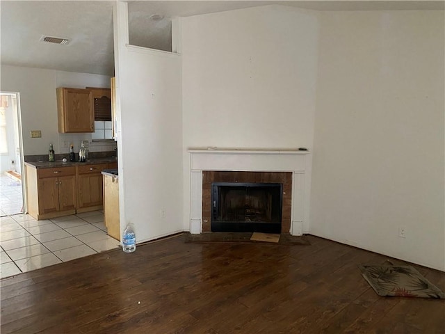 unfurnished living room with light hardwood / wood-style flooring and a tile fireplace