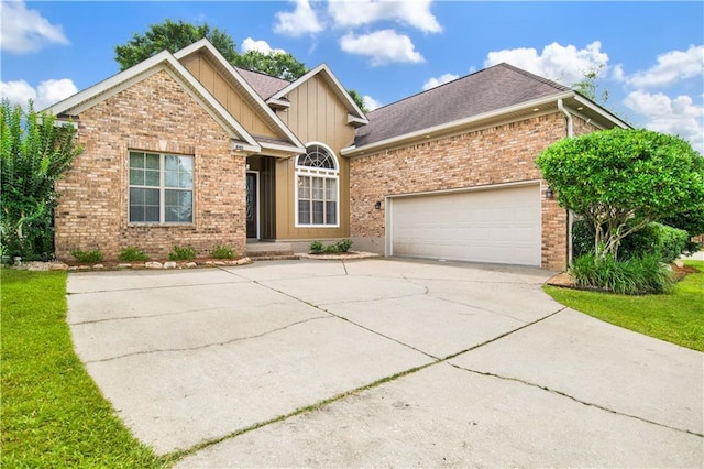 3245 Mcrae Dr, Mobile, AL 36695 - view of front of house featuring brick siding, board and batten siding, driveway, a garage, and roof with shingles