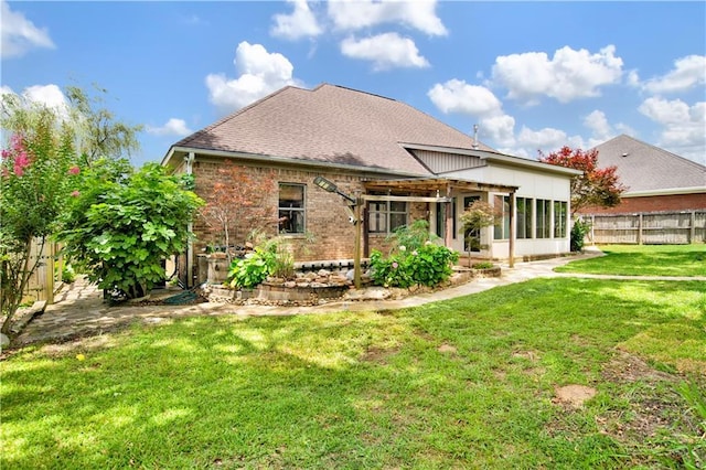 3245 Mcrae Dr, Mobile, AL 36695 - back of house featuring a fenced backyard, a shingled roof, brick siding, and a sunroom