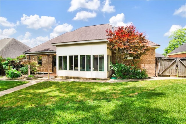 3245 Mcrae Dr, Mobile, AL 36695 - back of house featuring a sunroom, brick siding, and a gate