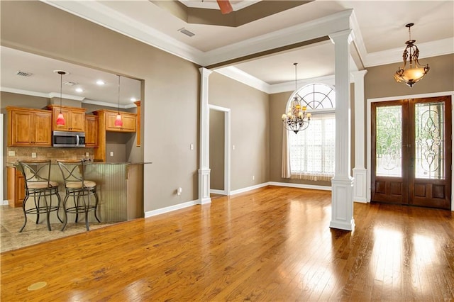 3245 Mcrae Dr, Mobile, AL 36695 - entrance foyer with decorative columns, ornamental molding, french doors, light wood-type flooring, and a chandelier