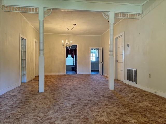 spare room featuring a chandelier, ornamental molding, carpet, and a towering ceiling